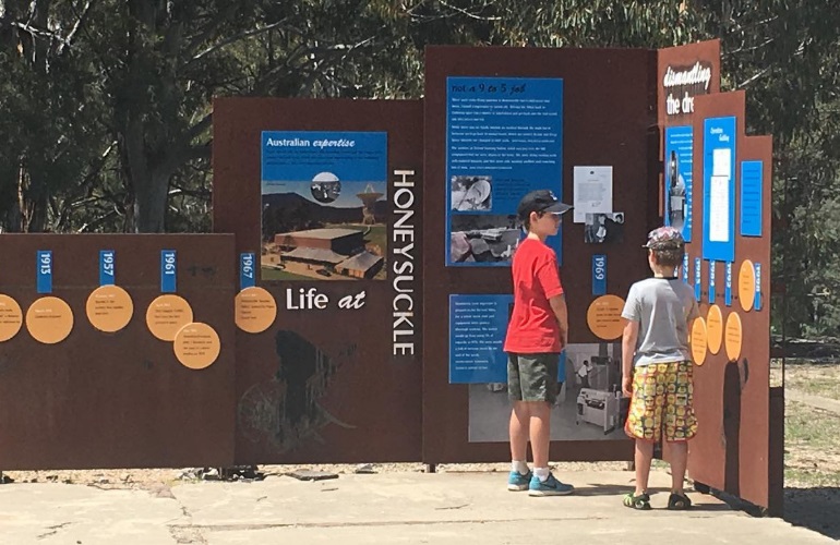 Image of two children looking at historic display at Honeysuckle Campgrounds, Canberra