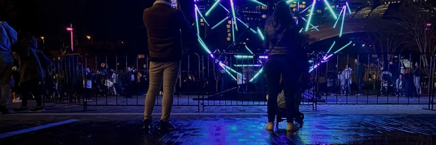 black backdrop with people standing nearby taking photos