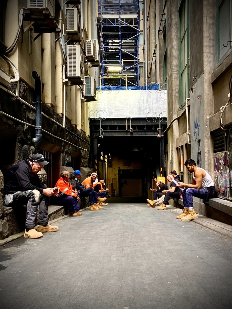 Photo of a group of construction workers taking a break in one of the laneways near Hosier Lane Melbourne