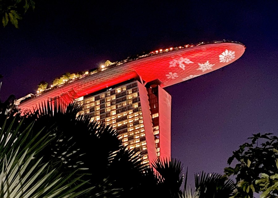 Night shot of building in Singapore with Singapore flag projected underneath the overhanging area